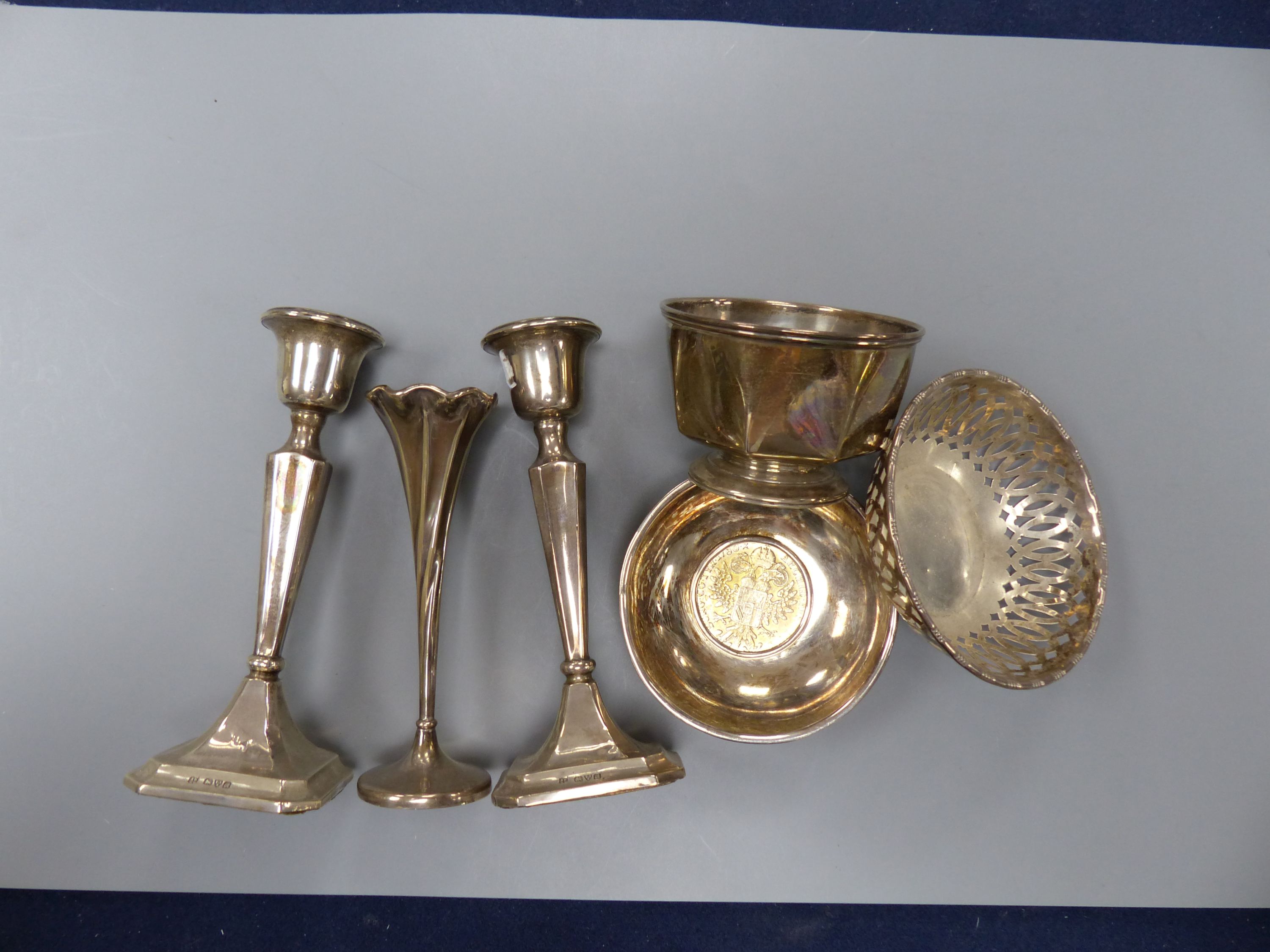 A pair of George V silver mounted candlesticks, 15.2cm, a silver posy vase, silver bowl, silver pierced dish and a 925 inset coin dish.